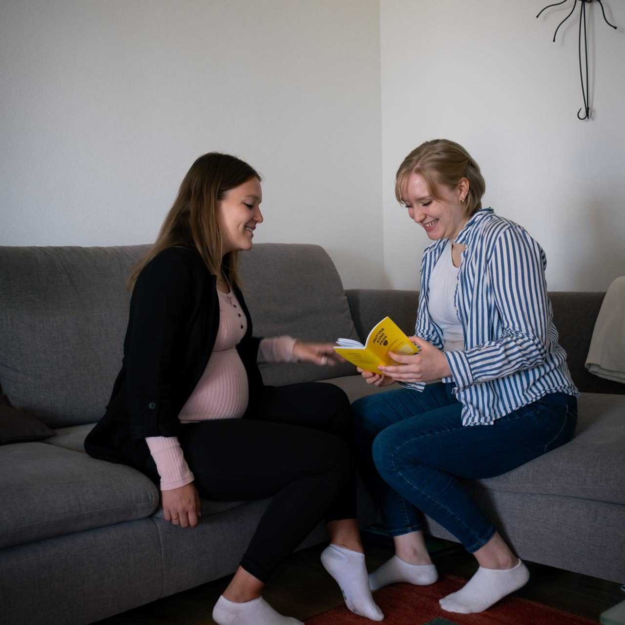 Maya erklärt einer schwangeren Frau den Eltern-Kind-Pass